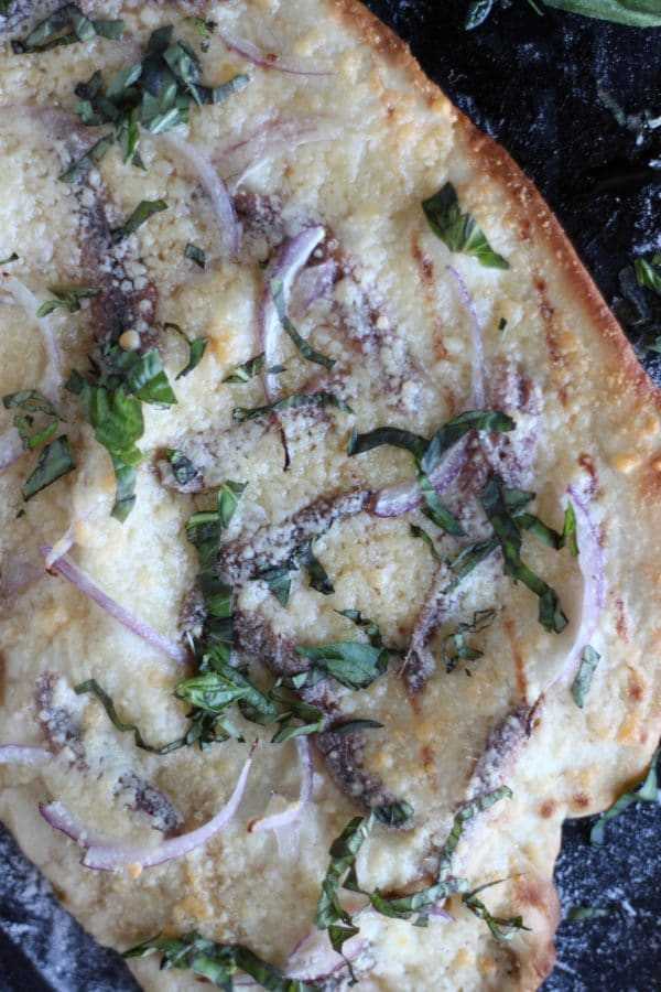 Beer Pizza Crust Anchovies and Red Onions Close Up