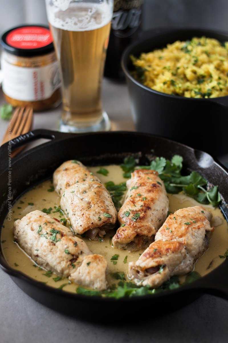 Beer chicken roulades in cast iron skillet, stuffed with curry garlic and onions and simmered in a delicious sauce of Witbier and coconut milk. #cookingwithbier #chickenroulades #chickenrecipe #beerchicken #currygarlic
