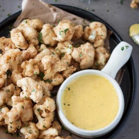 Best fried cauliflower bites ever. Light crunchy batter flavored with red pepper flakes (optional) and served with curry garlic lime aioli. Superb! #friedcauliflower #beerbattered