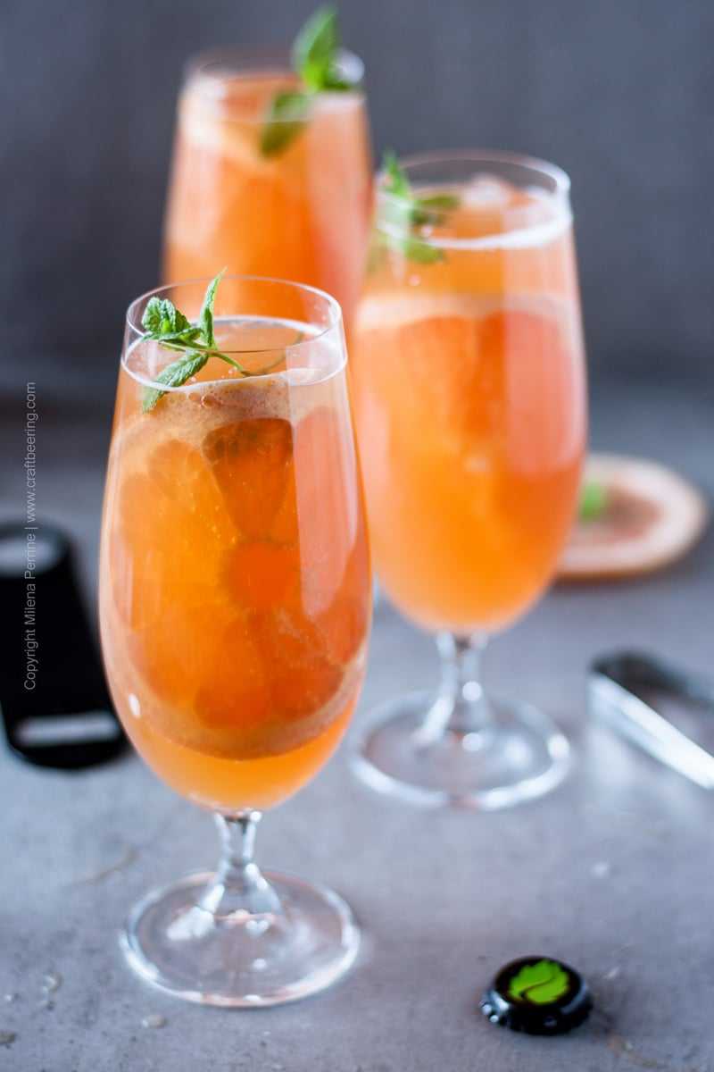 Grapefruit beer shandy filled glasses with a fresh mint and pink grapefruit garnish. Awesome summer shandy recipe. #craftbeer #beercocktails #grapefruitbeer #summershandy
