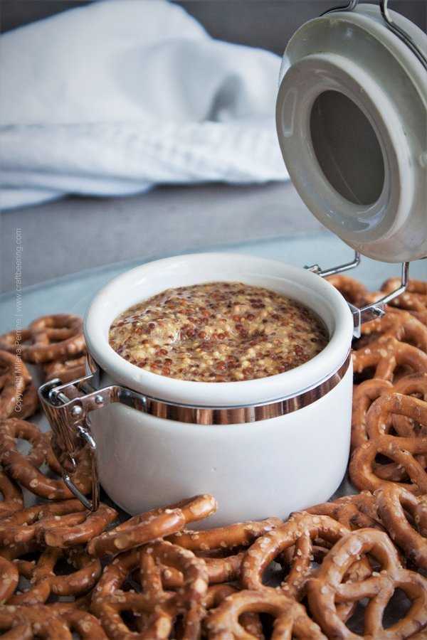 Beer Mustard presented as a dip fro pretzels in a white container. 