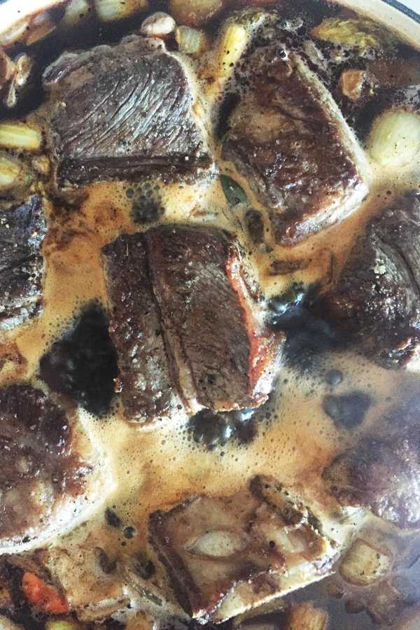 Seared short ribs are added to the braising liquid and brought to a boil