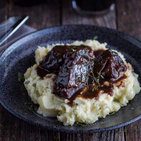 Beer braised short ribs served over mashed potatoes and garnished with thyme and parsley