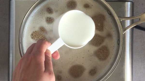 Add cream to simmering beer in pot.