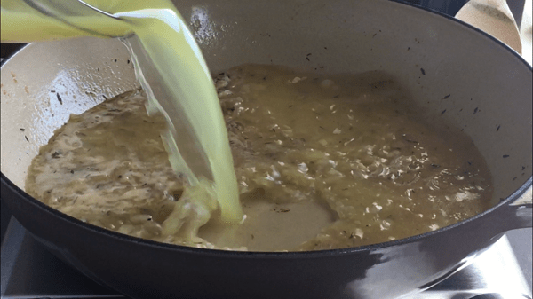 Chicken stock is added to deglazed pan. 