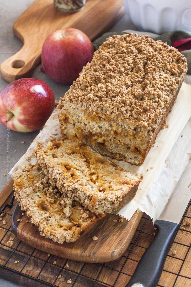 Streusel apple bread loaf with slices showing light texture dotted with caramel chips.