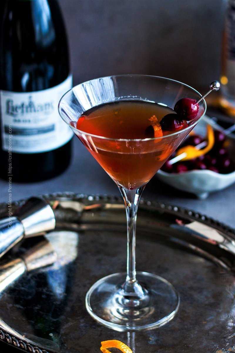 Manhattan drink - the cocktail shown in a martini glass over a silver tray.