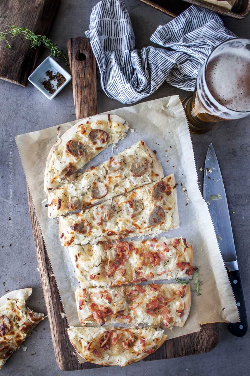 Sauerkraut pizzas with different toppings, sliced and served side by side on a rustic cutting board.