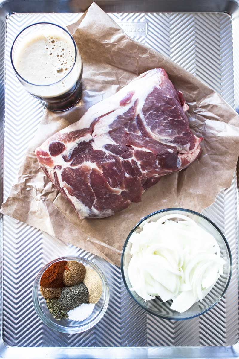 Pork shoulder (boneless), spices, sliced onions and brown ale - ingredients for beer pulled pork in slow cooker. 