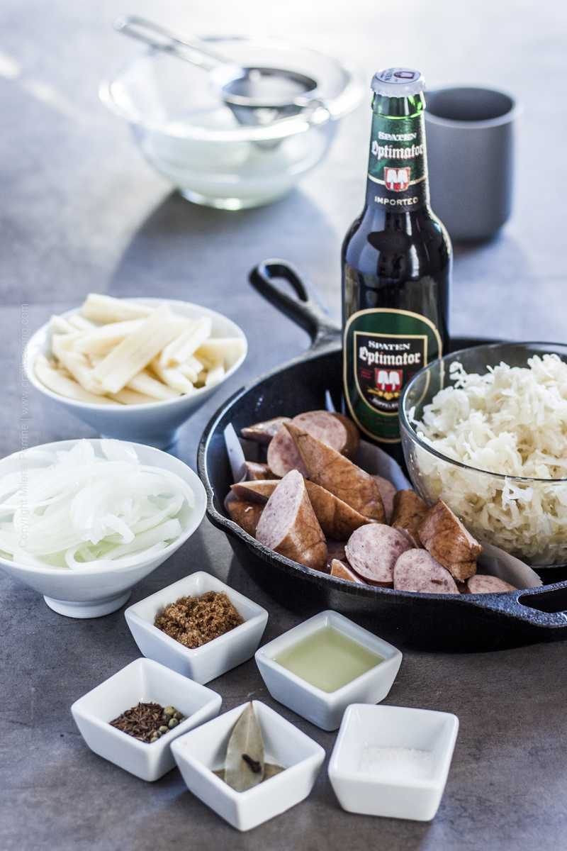 Sauerkraut, Polish kielbasa, apple, onions and other ingredients for sauerkraut sausage skillet.