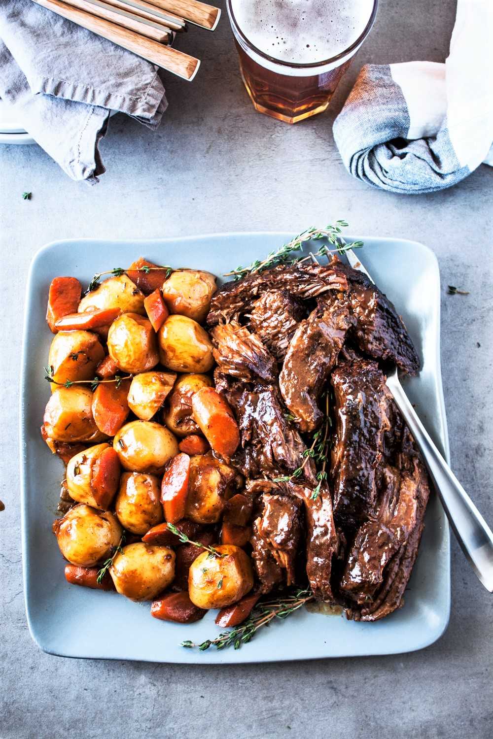 Beer braised pot roast plated with potatoes and carrots.