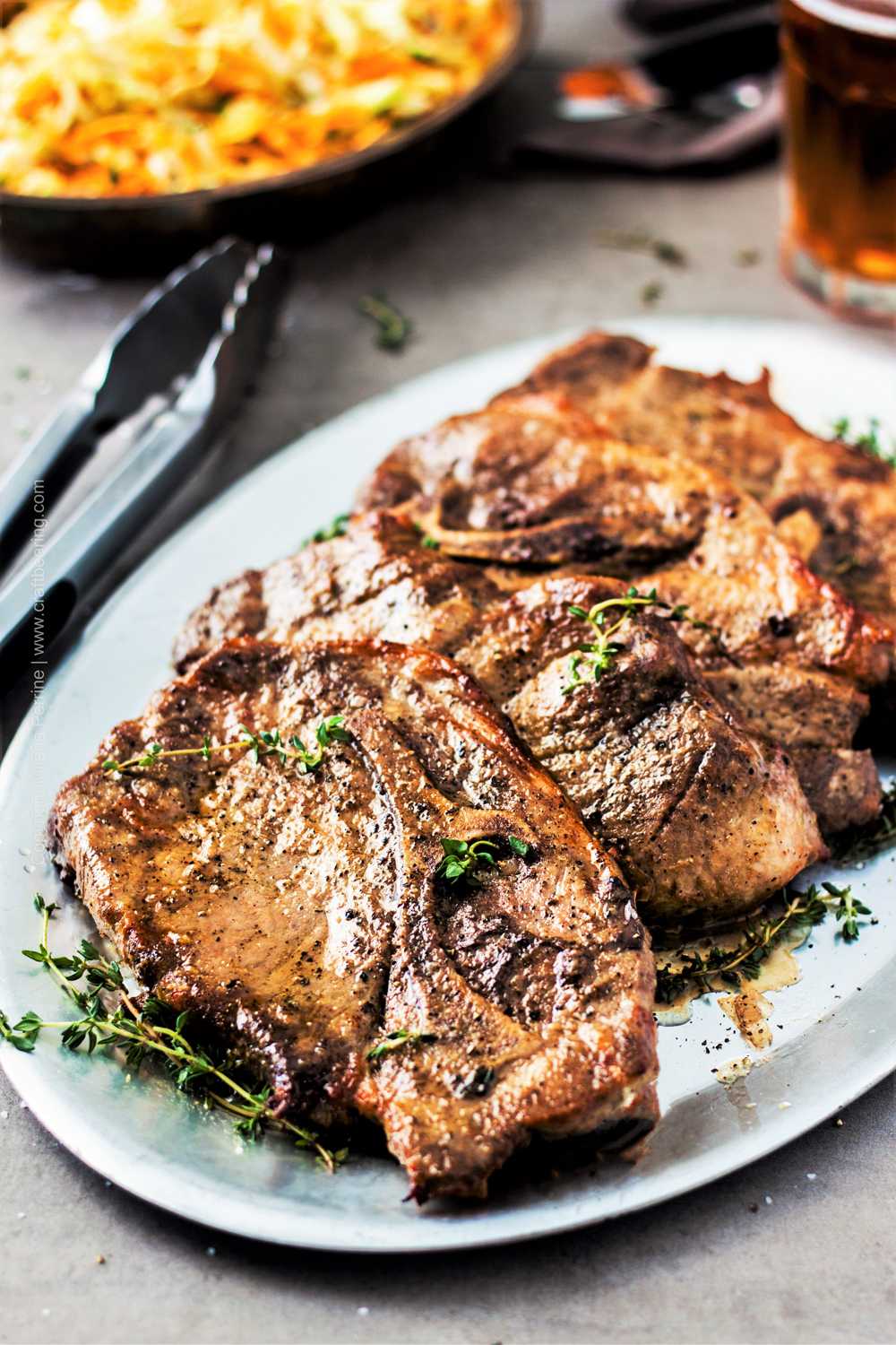 Oven baked pork steaks (with shoulder blade visible), marinated and well seasoned. 