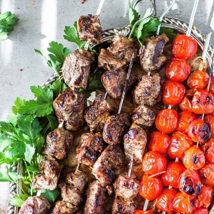 Grilled lamb skewers aka shish kebab. Traditionally presented with sumac onions, fire roasted or fresh tomatoes and parsley.