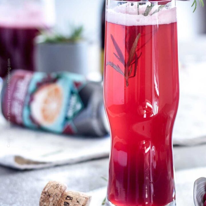 Prosecco Cranberry Shandy Cocktail garnished with Cranberries and rosemary