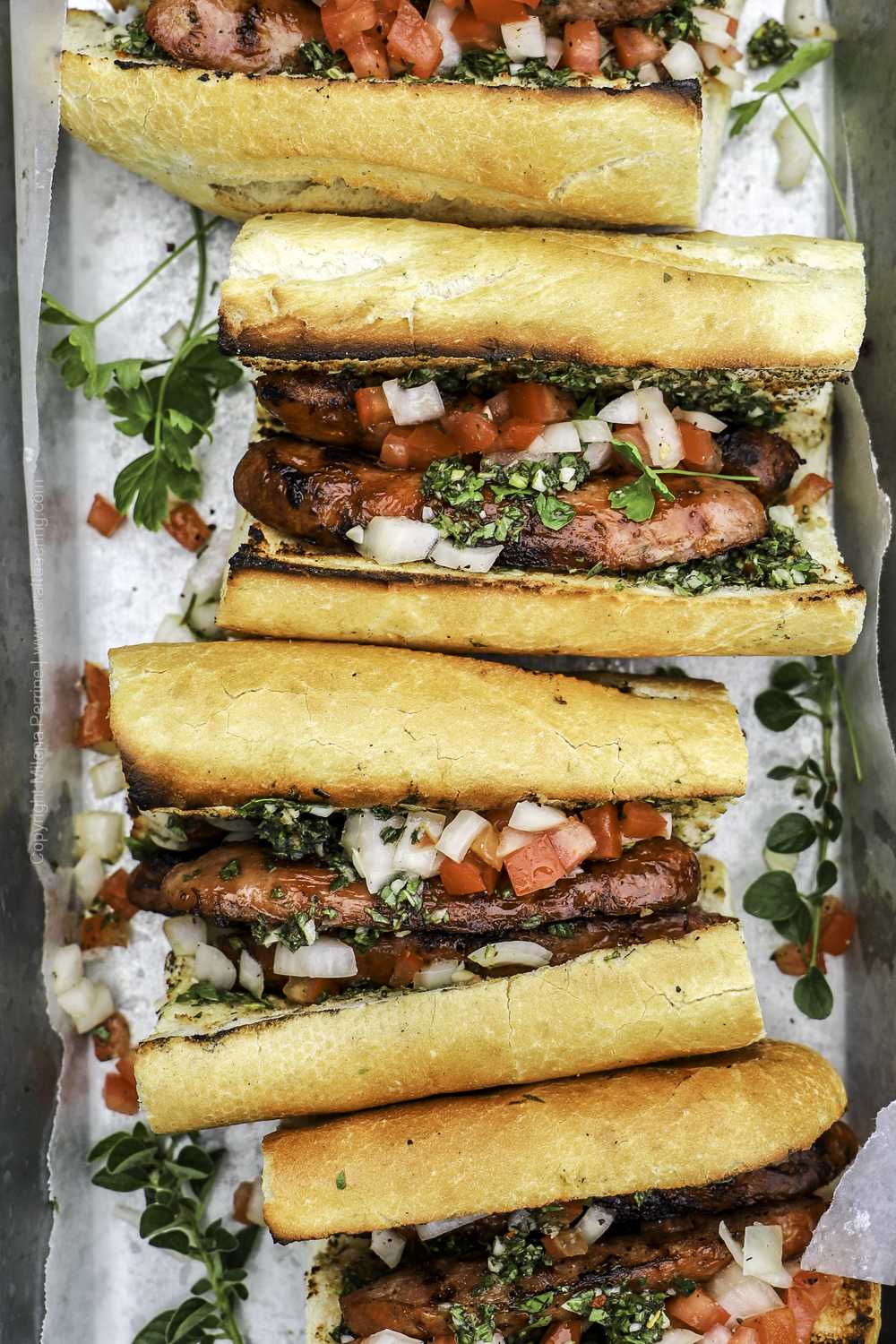 Choripán sandwiches with salsa Criolla and chimichurri sauce