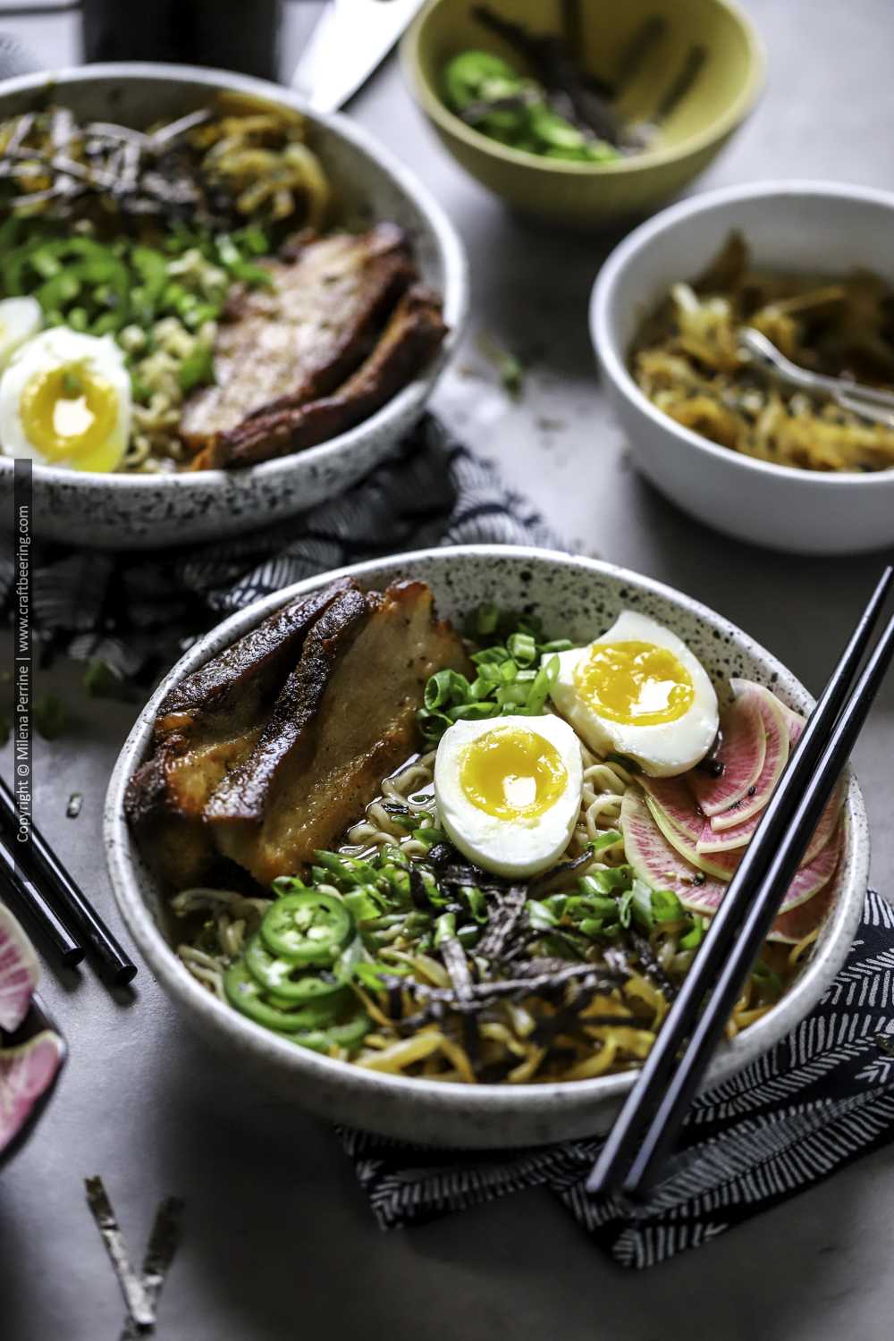 Pork ramen bowl with crispy pork belly slices, soft boiled egg, nori, bean sprouts and watermelon radish.