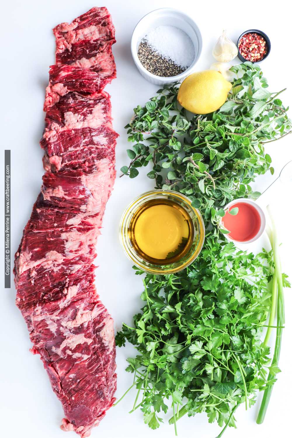Raw outside skirt steak with herbs and other ingredients for chimichurri - the making of entrana a la parilla.