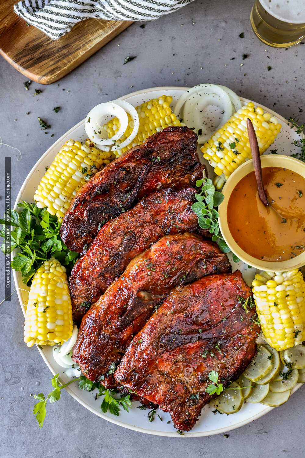 Smoked pork steaks on platter with corn on the cob.