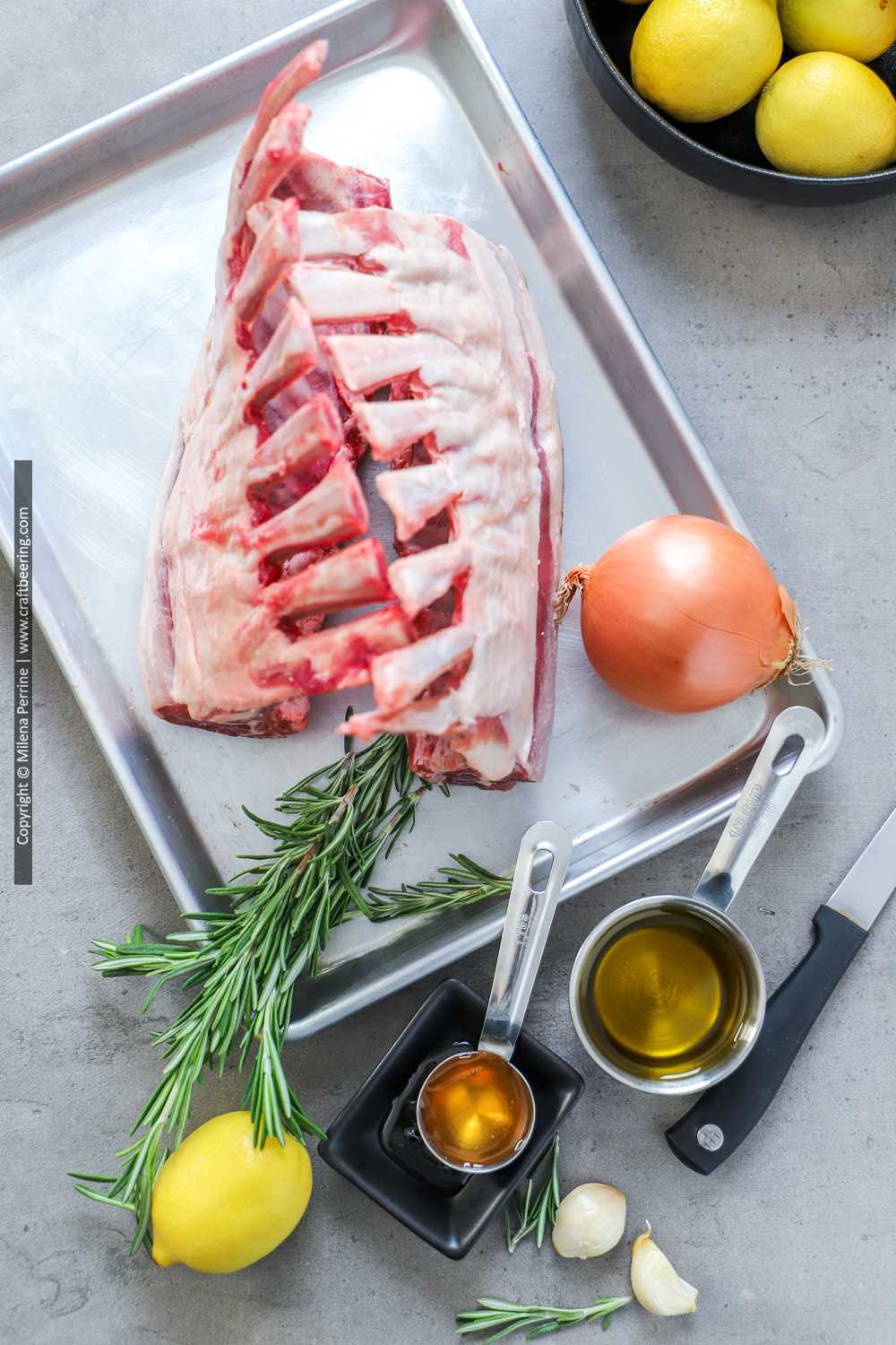 Raw racks of lamb with ingredients for rosemary marinade.