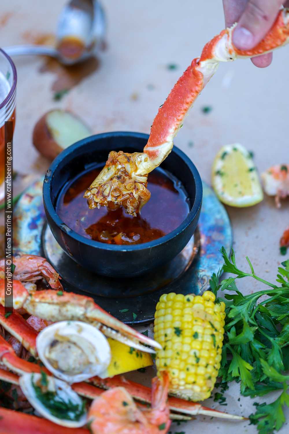 Crab boil sauce with snow crab meat dipped in it.
