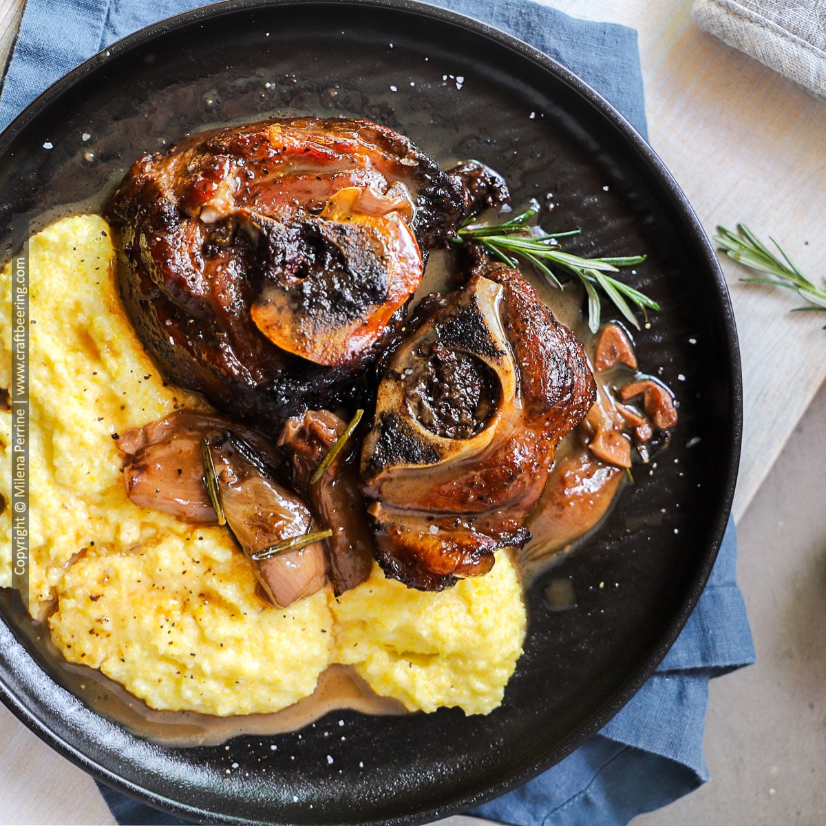 Braised lamb necks are shown served with polenta and shallots on a contrasting black plate.
