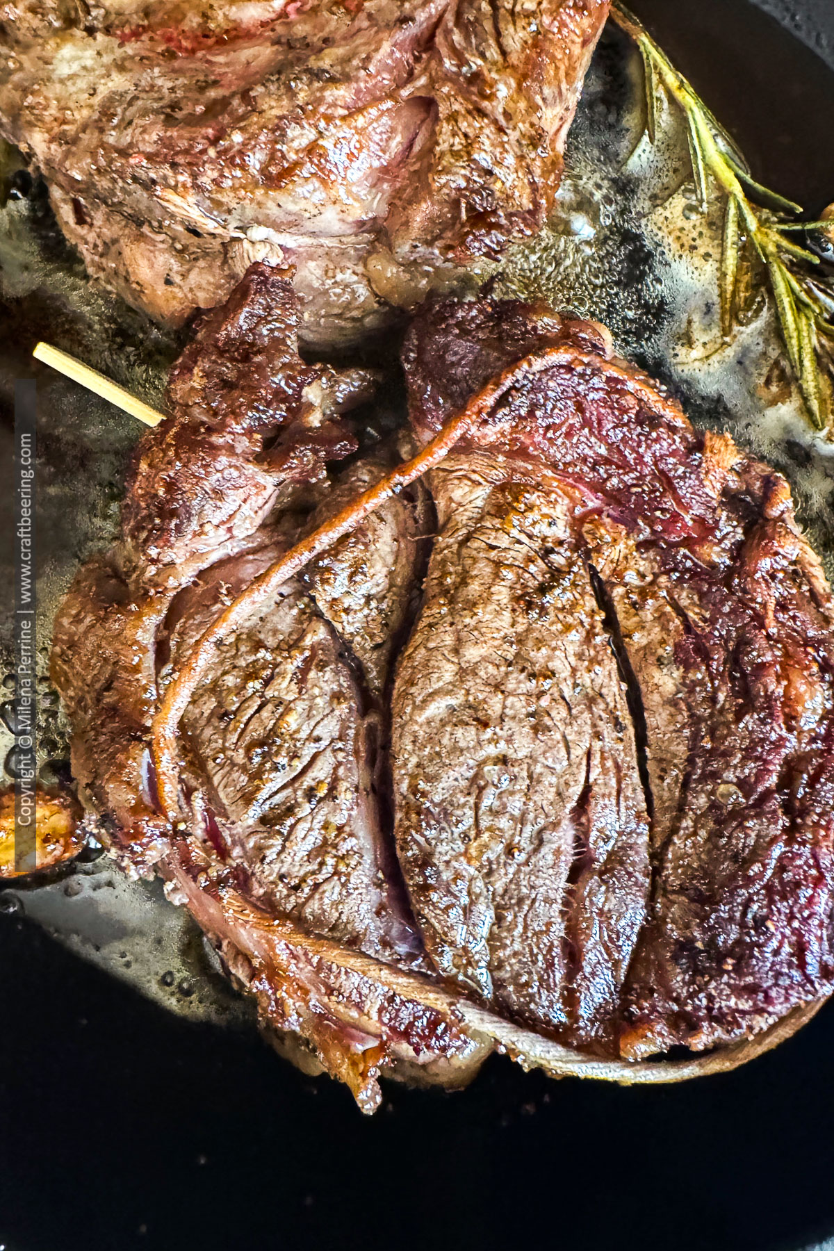 Chuck eye steak with a small wooden skewer inserted to hold it together while being seared with butter.
