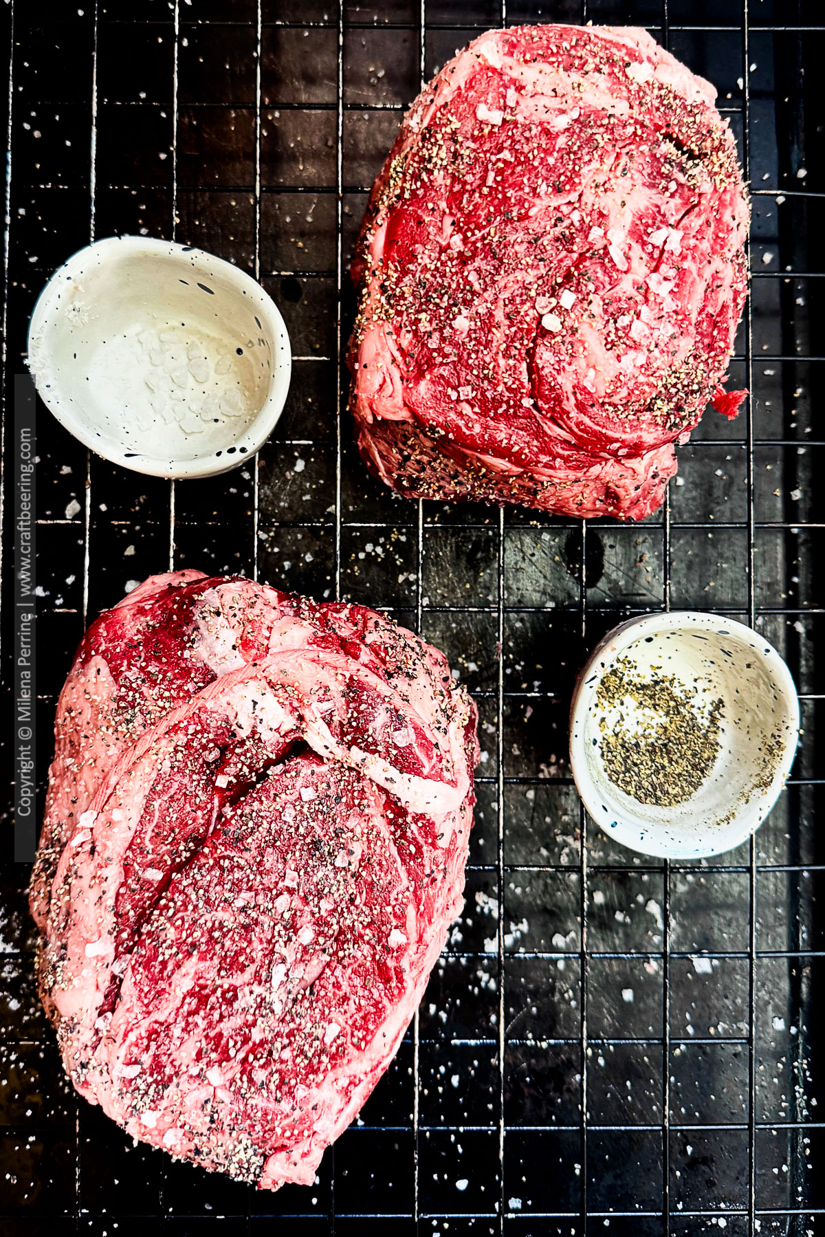 Two raw chuck eye steaks tied with butcher's twine are shown resting over wire rack fitted baking sheet.
