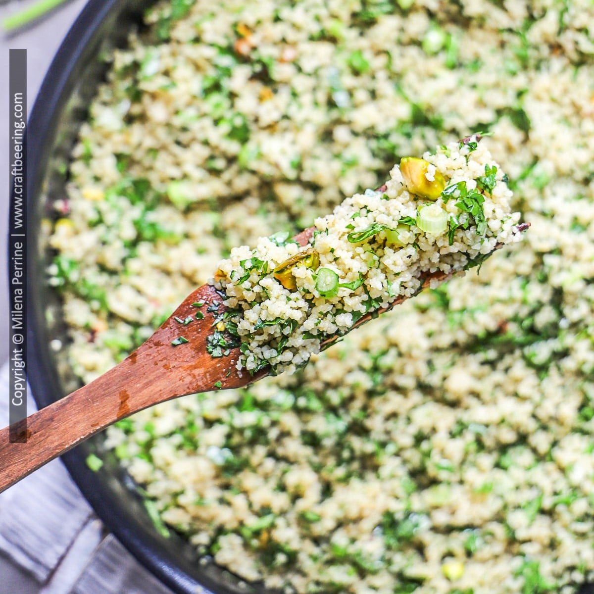 Detailed view from above of a spoonful of Moroccan couscous with herbs and pistachios.