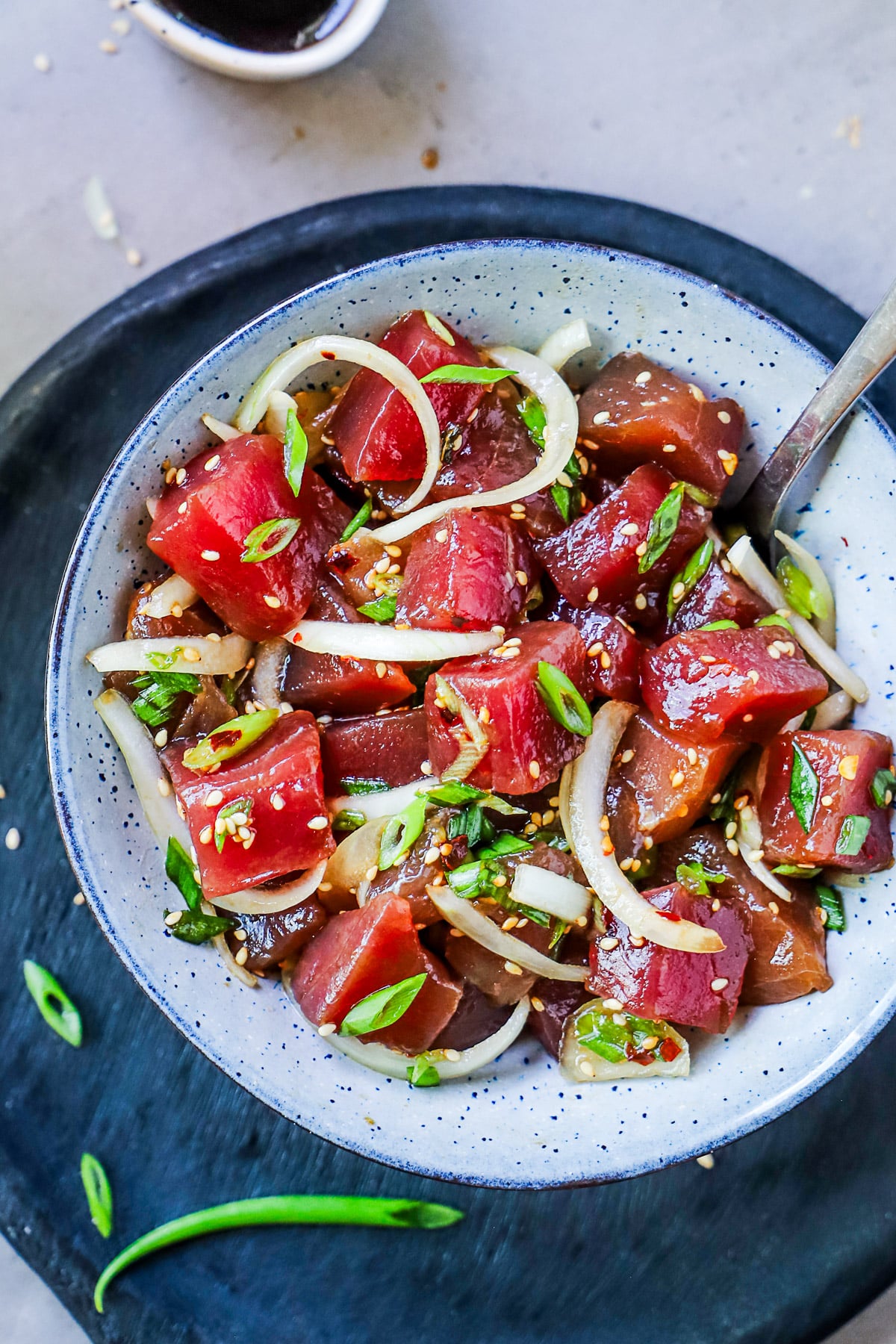 Shoyu yellowfin tuna poke in a blue bowl, viewed from above.