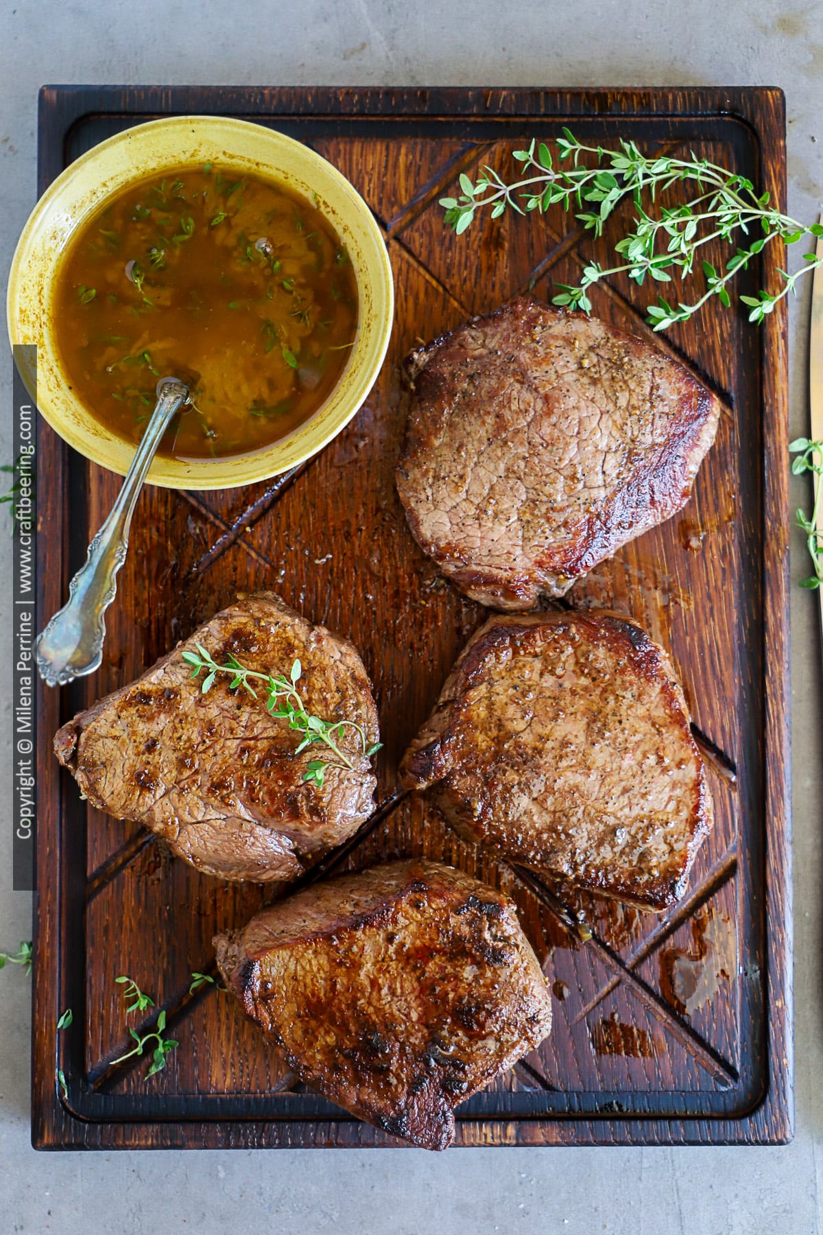 Seared top sirloin filet is shown resting on a wooden cutting board