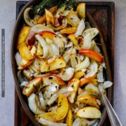Baked apples and onions with sage and thyme are shown in an oval serving dish.