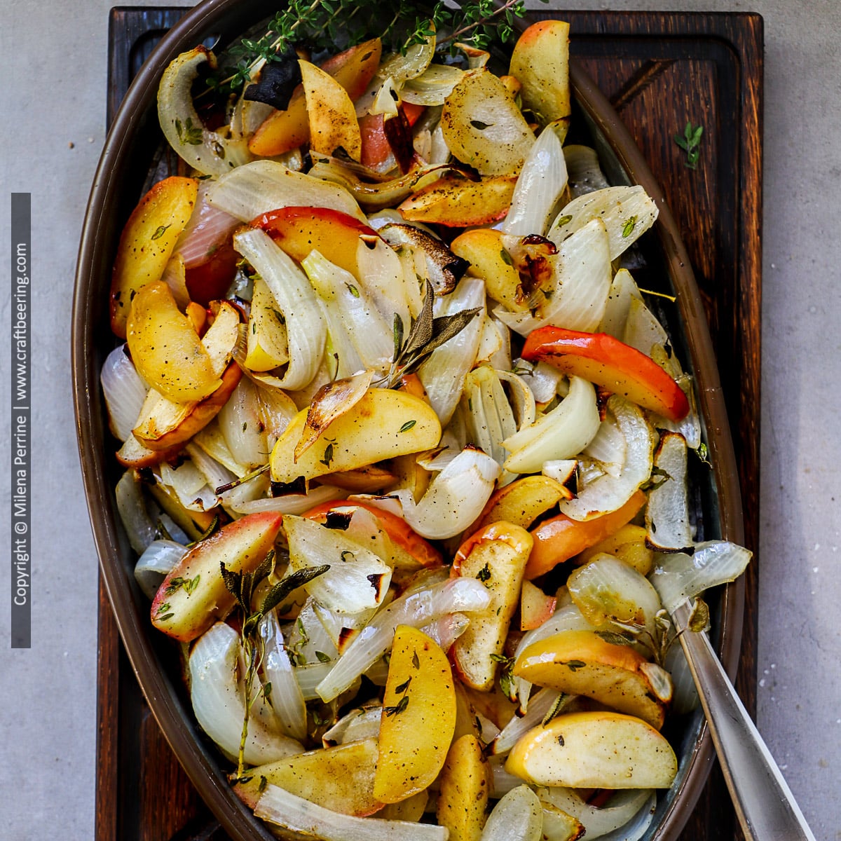 Baked apples and onions with sage and thyme are shown in an oval serving dish.
