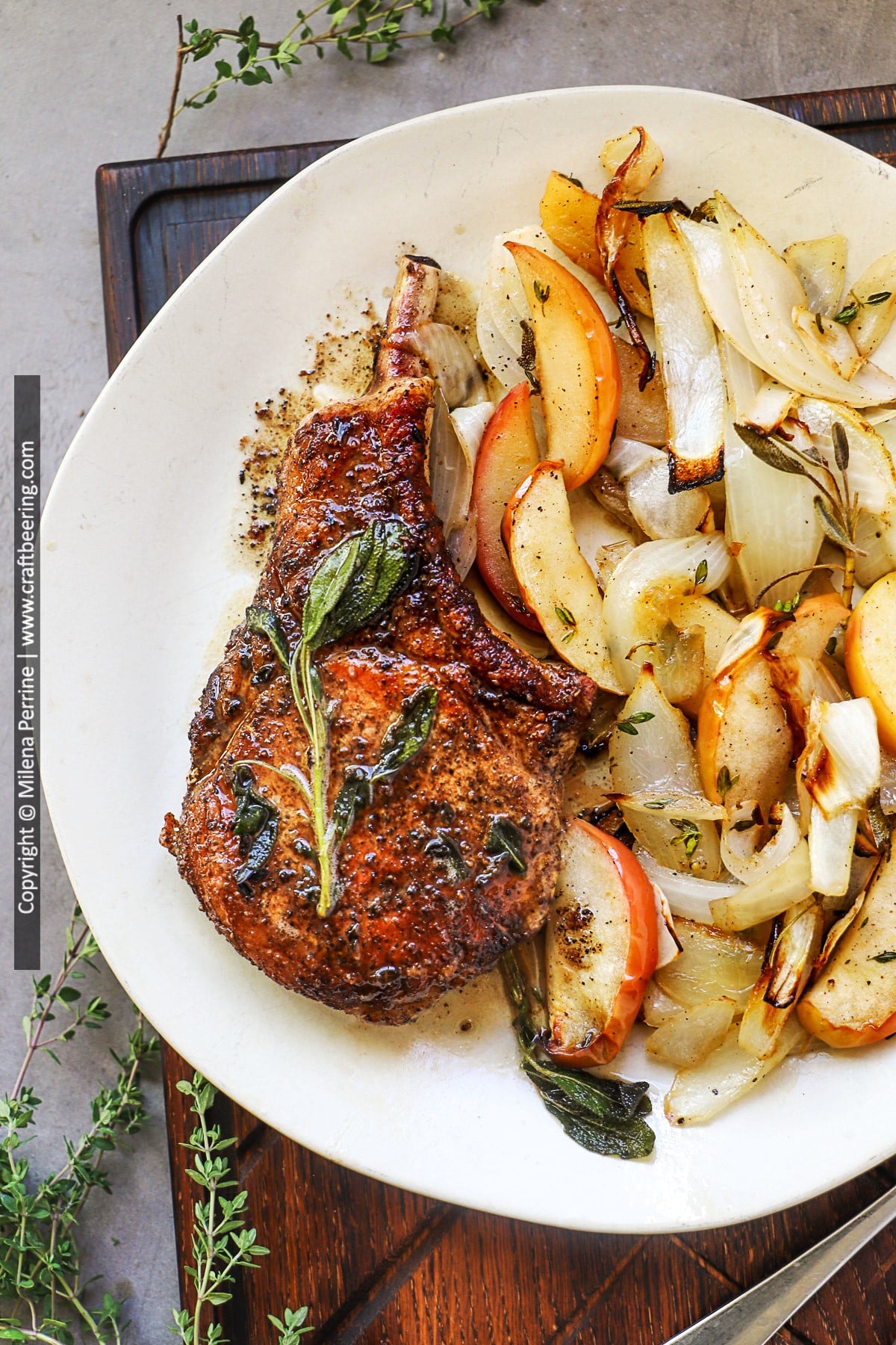 Pork chops with apples and onions shown plated and viewed from above.