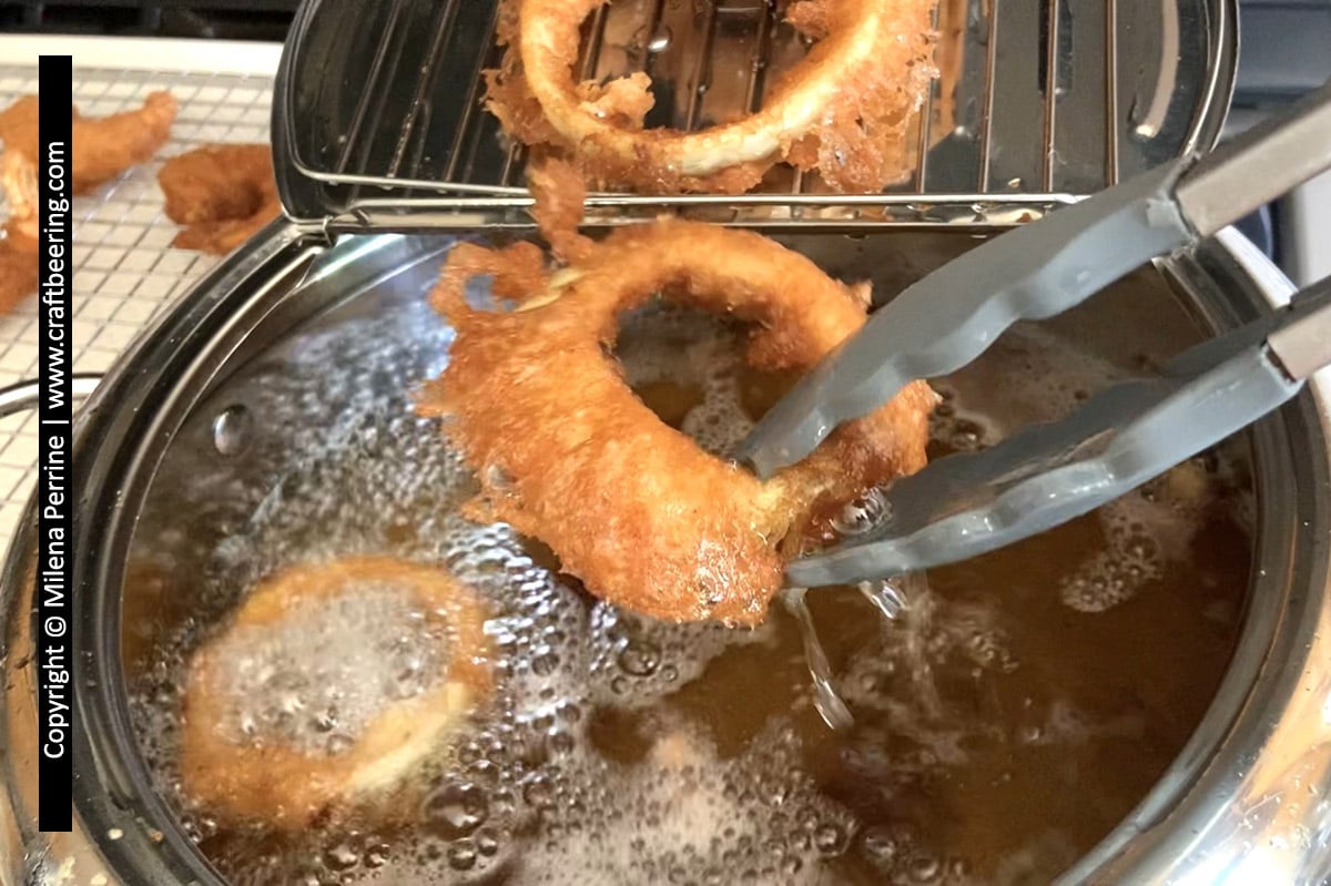 Onion rings being fried in a tempura frying pot
